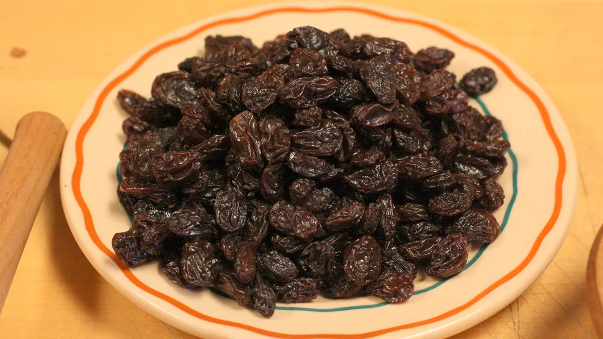 Cuenco con uvas y pasas sobre una encimera